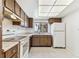 Bright kitchen with white appliances, wood cabinets, tiled floors, and a window with natural light at 880 S Village Lake N Dr # 106, St Petersburg, FL 33716