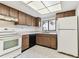 Well-lit kitchen featuring tiled flooring, essential appliances, and ample wood cabinetry at 880 S Village Lake N Dr # 106, St Petersburg, FL 33716