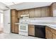 Functional kitchen with tiled floors, white appliances, and ample wood cabinetry at 880 S Village Lake N Dr # 106, St Petersburg, FL 33716