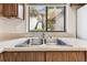 Kitchen with double sink, wood cabinetry and window providing natural light at 880 S Village Lake N Dr # 106, St Petersburg, FL 33716