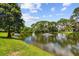 Scenic pond view featuring a fountain surrounded by lush greenery and blue skies at 880 S Village Lake N Dr # 106, St Petersburg, FL 33716