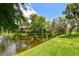Picturesque pond with lush greenery along the banks and residences in the background at 880 S Village Lake N Dr # 106, St Petersburg, FL 33716