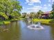 Beautiful view of the pond with a fountain and mature trees in this Clearwater, Florida condominium community at 880 S Village Lake N Dr # 106, St Petersburg, FL 33716