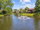 Lovely view of the pond with a fountain and mature trees in this Clearwater, Florida condominium community at 880 S Village Lake N Dr # 106, St Petersburg, FL 33716