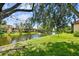 Scenic pond view lined with trees, shrubbery, and residences in the distance at 880 S Village Lake N Dr # 106, St Petersburg, FL 33716