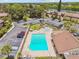 Aerial view of a community pool, playground, and parking lot surrounded by lush greenery and residential buildings at 880 S Village Lake N Dr # 106, St Petersburg, FL 33716