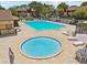 Aerial view of a community pool with a hot tub, lounge chairs, and tables, perfect for relaxation and recreation at 880 S Village Lake N Dr # 106, St Petersburg, FL 33716