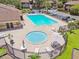 Aerial view of a community pool area with a large pool and hot tub surrounded by lounge chairs and tables at 880 S Village Lake N Dr # 106, St Petersburg, FL 33716