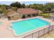 Aerial view of a community pool with lounge chairs, tables, and a pool house, offering a relaxing and convenient amenity at 880 S Village Lake N Dr # 106, St Petersburg, FL 33716