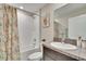 Bathroom with tiled shower, decorative shower curtain, vanity, and patterned towels at 11210 Kelly Green Ave, Wimauma, FL 33598