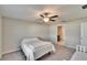 Minimalist bedroom with a bed, ceiling fan, and ensuite bathroom at 11210 Kelly Green Ave, Wimauma, FL 33598