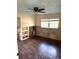 Partially renovated bedroom featuring dark wood floors and a ceiling fan at 2450 Roberta Ln, Clearwater, FL 33764