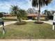 Charming single-story home featuring a lush, manicured lawn with mature palm trees at 2450 Roberta Ln, Clearwater, FL 33764