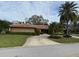 Well-maintained single-story home showcasing a circular driveway and mature landscaping at 2450 Roberta Ln, Clearwater, FL 33764