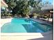 Inviting swimming pool featuring a covered outdoor dining area and lush greenery at 2450 Roberta Ln, Clearwater, FL 33764