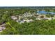 Wide aerial shot of a peaceful neighborhood with trees, a lake, and well-maintained homes at 4251 Whittner Dr, Land O Lakes, FL 34639