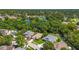 Scenic aerial view showing houses nestled among lush trees with a serene pond nearby at 4251 Whittner Dr, Land O Lakes, FL 34639