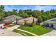 Aerial view of home with well maintained landscaping, driveway, and lush surrounding greenery at 4251 Whittner Dr, Land O Lakes, FL 34639