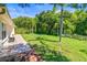 Backyard featuring a paved area near the house and a lawn with trees extending into the distance at 4251 Whittner Dr, Land O Lakes, FL 34639