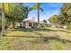Well-maintained backyard with mature trees and a neatly kept lawn surrounding the home at 4251 Whittner Dr, Land O Lakes, FL 34639
