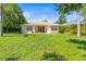 A lush backyard with green grass, mature trees, and a patio area perfect for outdoor gatherings at 4251 Whittner Dr, Land O Lakes, FL 34639