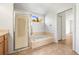 Bathroom featuring glass-enclosed shower and separate soaking tub with tiled surround at 4251 Whittner Dr, Land O Lakes, FL 34639
