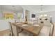 Open dining room with a wood table set for six, with view into a living room at 4251 Whittner Dr, Land O Lakes, FL 34639