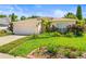 Charming single-story home featuring a well-manicured lawn and lush, colorful landscaping enhancing curb appeal at 4251 Whittner Dr, Land O Lakes, FL 34639