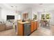 Open concept kitchen with stainless steel appliances, island, and dining area featuring natural light at 4251 Whittner Dr, Land O Lakes, FL 34639