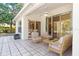 A covered patio with a ceiling fan, light colored furniture, and sliding glass doors into the house at 4251 Whittner Dr, Land O Lakes, FL 34639