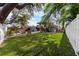 Expansive backyard with lush green lawn, palm trees, modern outdoor furniture, and privacy fence at 710 S Davis Blvd, Tampa, FL 33606