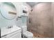 Bathroom featuring a tiled shower and a vanity with a round mirror at 710 S Davis Blvd, Tampa, FL 33606