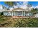 Charming blue brick home featuring a covered front porch with white columns and decorative glass front door at 710 S Davis Blvd, Tampa, FL 33606