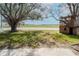 Landscaped front yard with mature trees and a charming wooden playhouse visible on a sunny day at 710 S Davis Blvd, Tampa, FL 33606