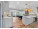 Bright kitchen featuring white cabinets, hardwood floors, pendant lighting, and an open concept design at 710 S Davis Blvd, Tampa, FL 33606