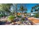 Charming home with a vibrant yellow exterior, surrounded by lush landscaping and trees at 830 S Davis Blvd, Tampa, FL 33606