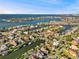 An aerial showcases a waterfront neighborhood with canals, private docks and homes with beautiful landscaping on a sunny day at 952 Symphony Isles Blvd, Apollo Beach, FL 33572