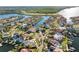 Aerial view of waterfront community with private docks and boats on canals surrounded by tropical landscaping and sunny skies at 952 Symphony Isles Blvd, Apollo Beach, FL 33572