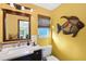 Vibrant bathroom with a sink, toilet, decorative fish art, and a window at 952 Symphony Isles Blvd, Apollo Beach, FL 33572