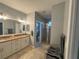 Bathroom featuring double vanity with granite countertop and a tiled shower with a glass door, creating a luxurious feel at 1314 Riserva Ln, Palm Harbor, FL 34683