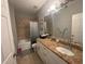Neutral bathroom featuring a granite countertop vanity, tiled shower over bath, and ample lighting at 1314 Riserva Ln, Palm Harbor, FL 34683