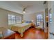 This bedroom offers hardwood floors, a ceiling fan, and a large window at 2749 Countryside Blvd # 4, Clearwater, FL 33761