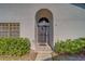 Arched entry with decorative metal security door and a hanging pendant light at 2749 Countryside Blvd # 4, Clearwater, FL 33761