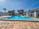 Outdoor pool with brick paver deck, lounge chairs and tropical landscaping on a sunny day at 2749 Countryside Blvd # 4, Clearwater, FL 33761