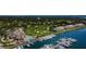Aerial view of a coastal community with golf course, marina with yachts, pool, and waterfront condominium buildings at 2775 Kipps Colony S Dr # 105, Gulfport, FL 33707