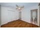 Bright bedroom with wood flooring and a ceiling fan plus a door to the primary bath at 2775 Kipps Colony S Dr # 105, Gulfport, FL 33707