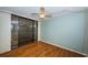 Bedroom featuring wood floors, large window with sliding glass doors, and a ceiling fan at 2775 Kipps Colony S Dr # 105, Gulfport, FL 33707