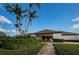Exterior view of the community clubhouse, featuring lush landscaping and blue skies at 2775 Kipps Colony S Dr # 105, Gulfport, FL 33707