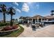 Clubhouse exterior featuring clock, outdoor seating, and meticulous landscaping, creating a welcoming atmosphere for members and guests at 2775 Kipps Colony S Dr # 105, Gulfport, FL 33707