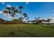 Clubhouse surrounded by manicured lawn, palm trees and blue sky at 2775 Kipps Colony S Dr # 105, Gulfport, FL 33707